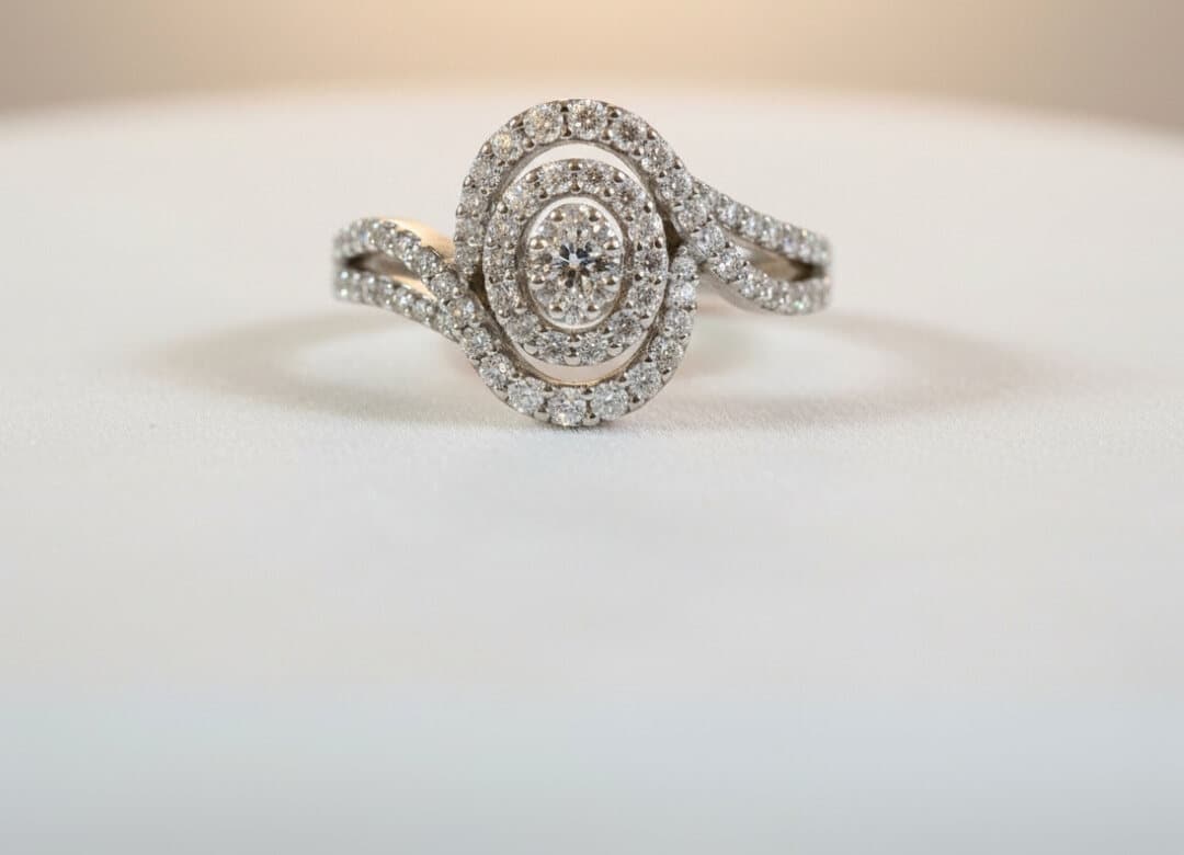 A white gold engagement ring with an oval diamond cluster in a double halo