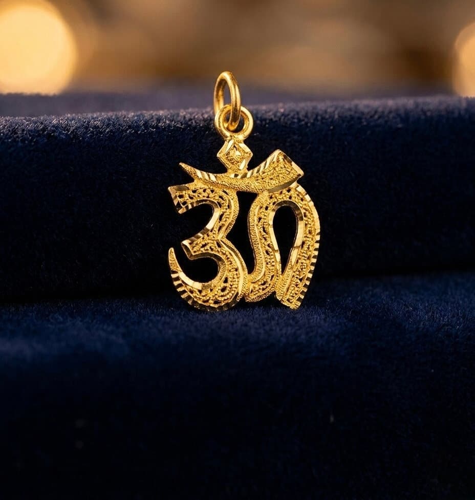 A 22ct gold Om pendant with filigree detail on dark velvet
