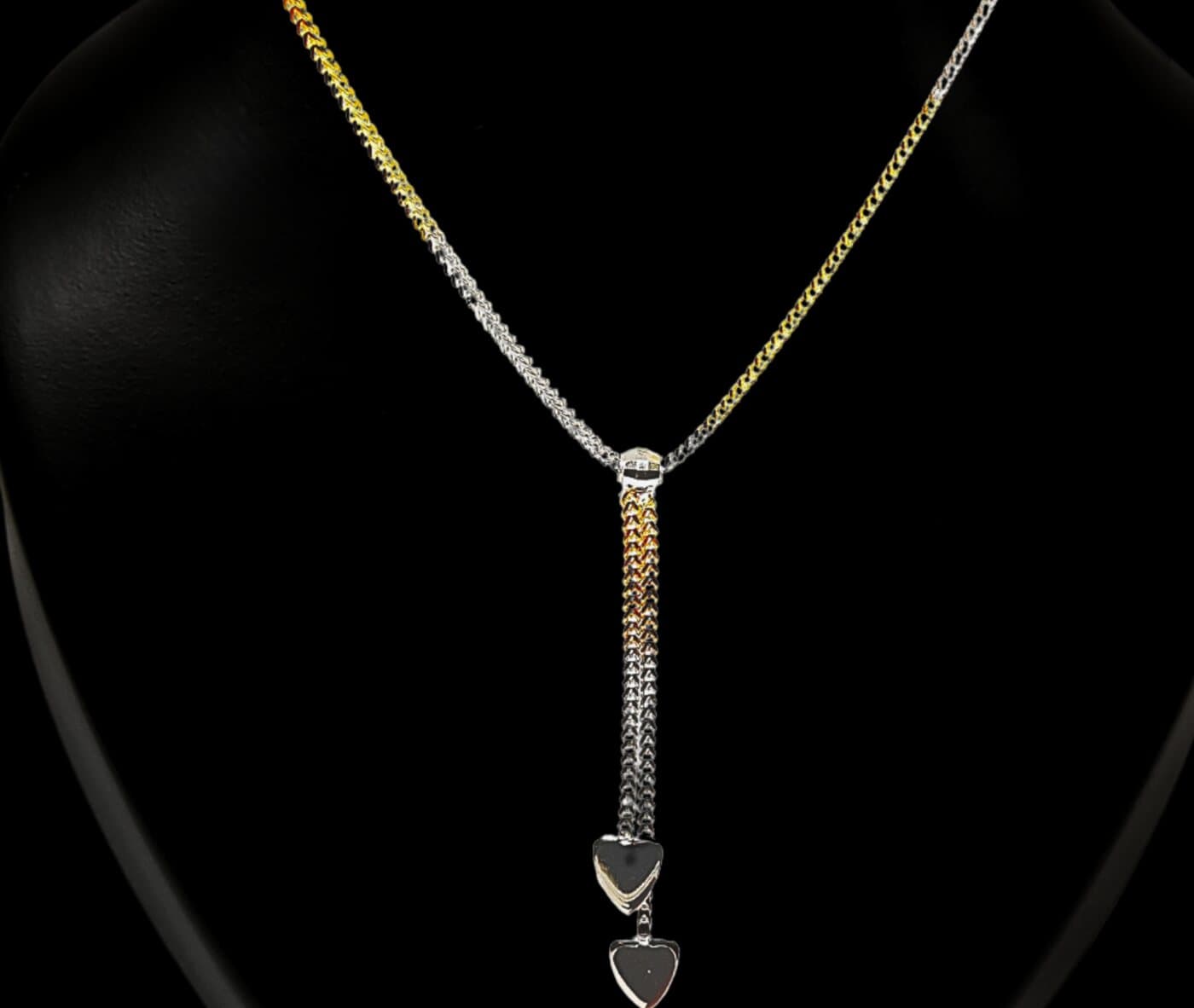 A two-tone gold lariat chain with heart drops