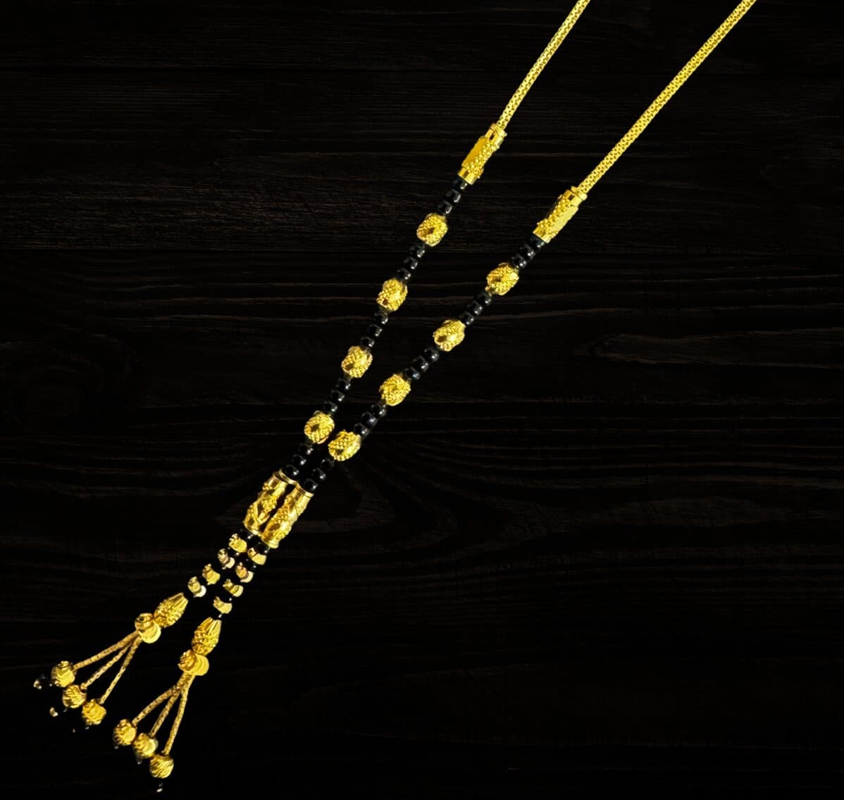 A 22ct gold and black bead mangalsutra with tassel ends