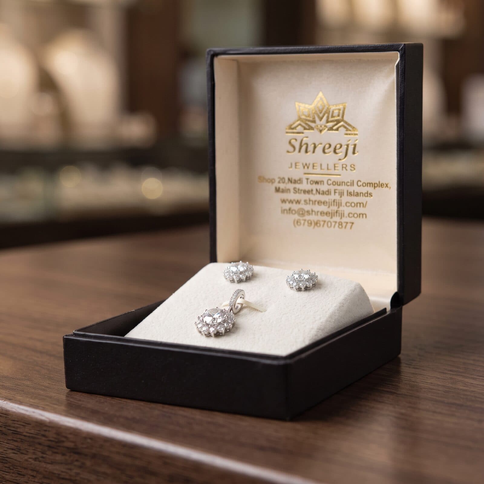 Sterling silver halo stud earrings and matching pendant in a Shreeji Jewellers gift box