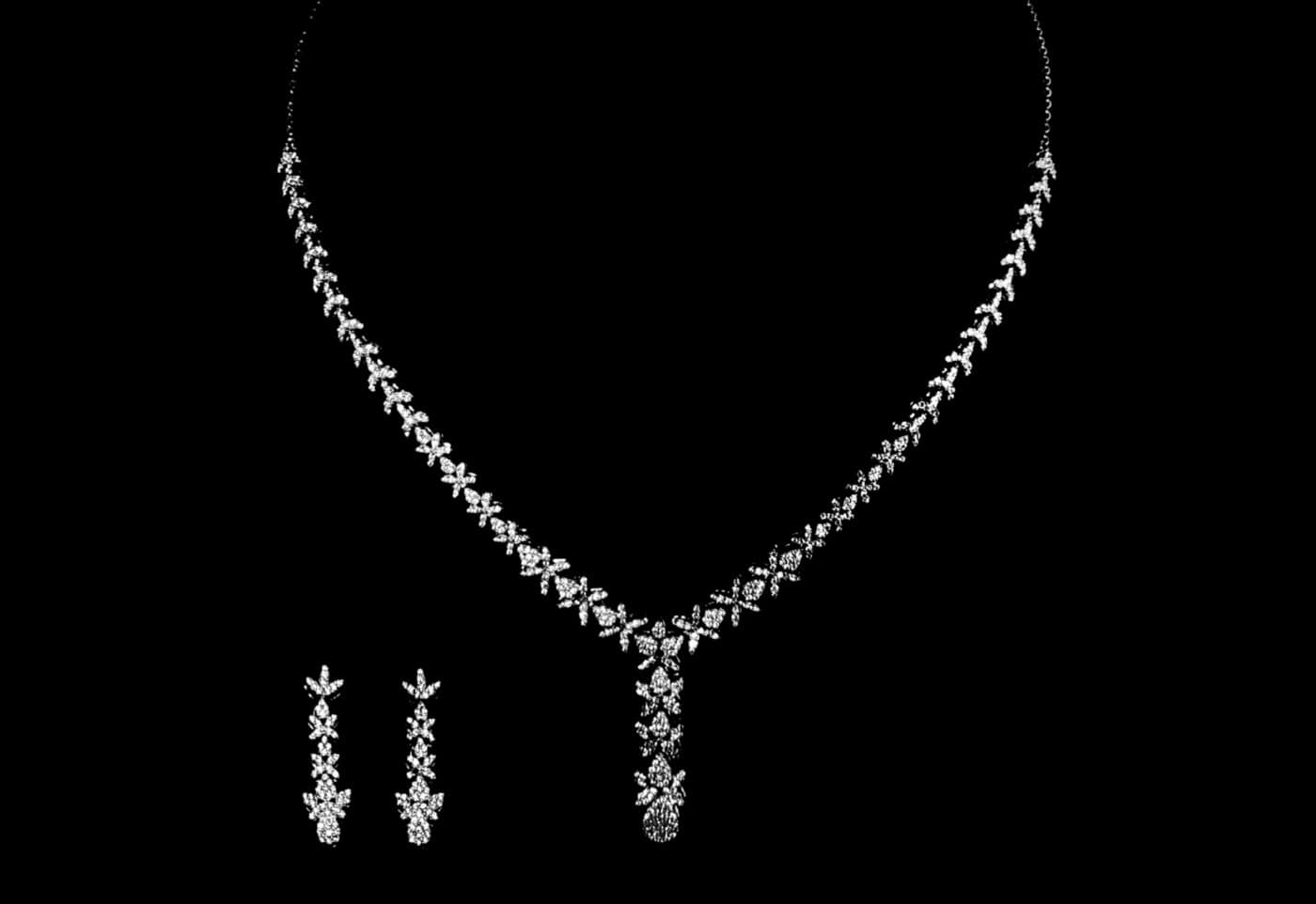 A sterling silver necklace and drop earring set with CZ stones, on black