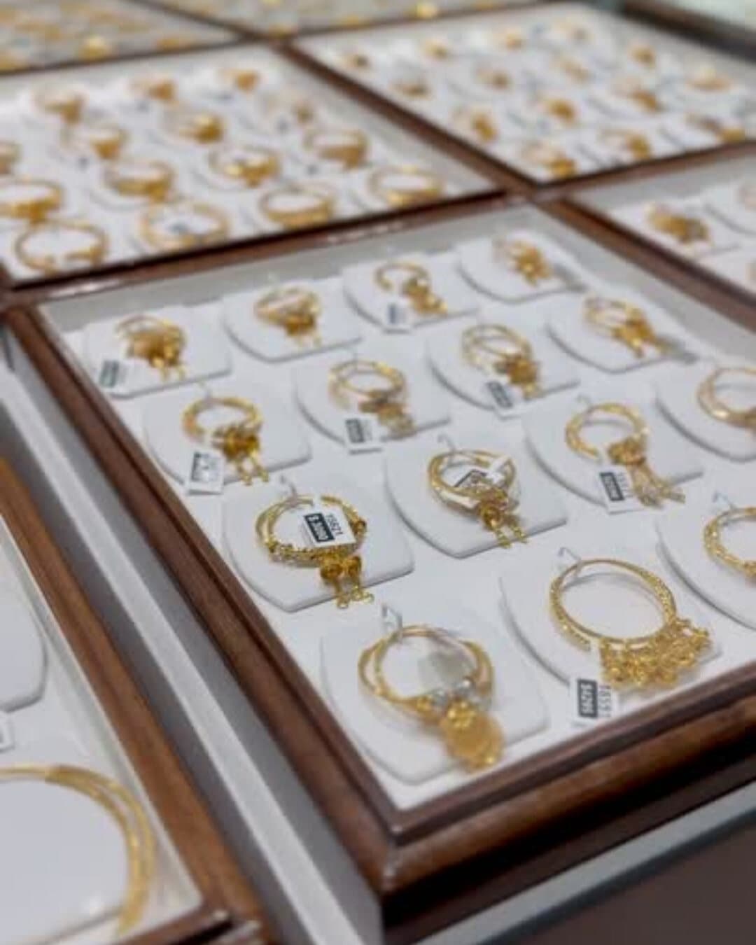 Trays of 22ct gold jhumka earrings in the display case at Shreeji Jewellers